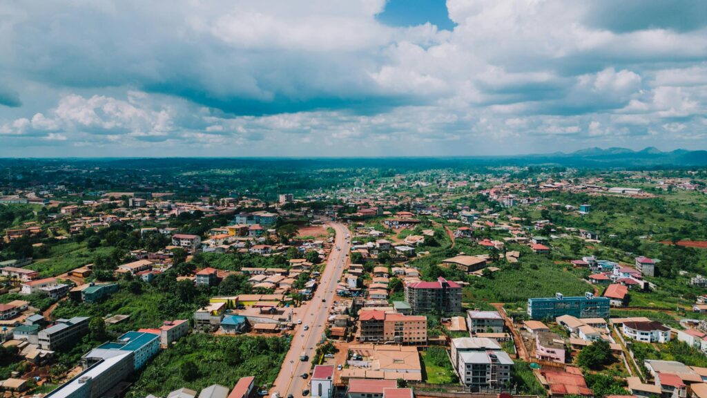 Enchanting Uganda Aerial cityscape of Yaoundé, Cameroon showcasing urban development under a vibrant sky.
