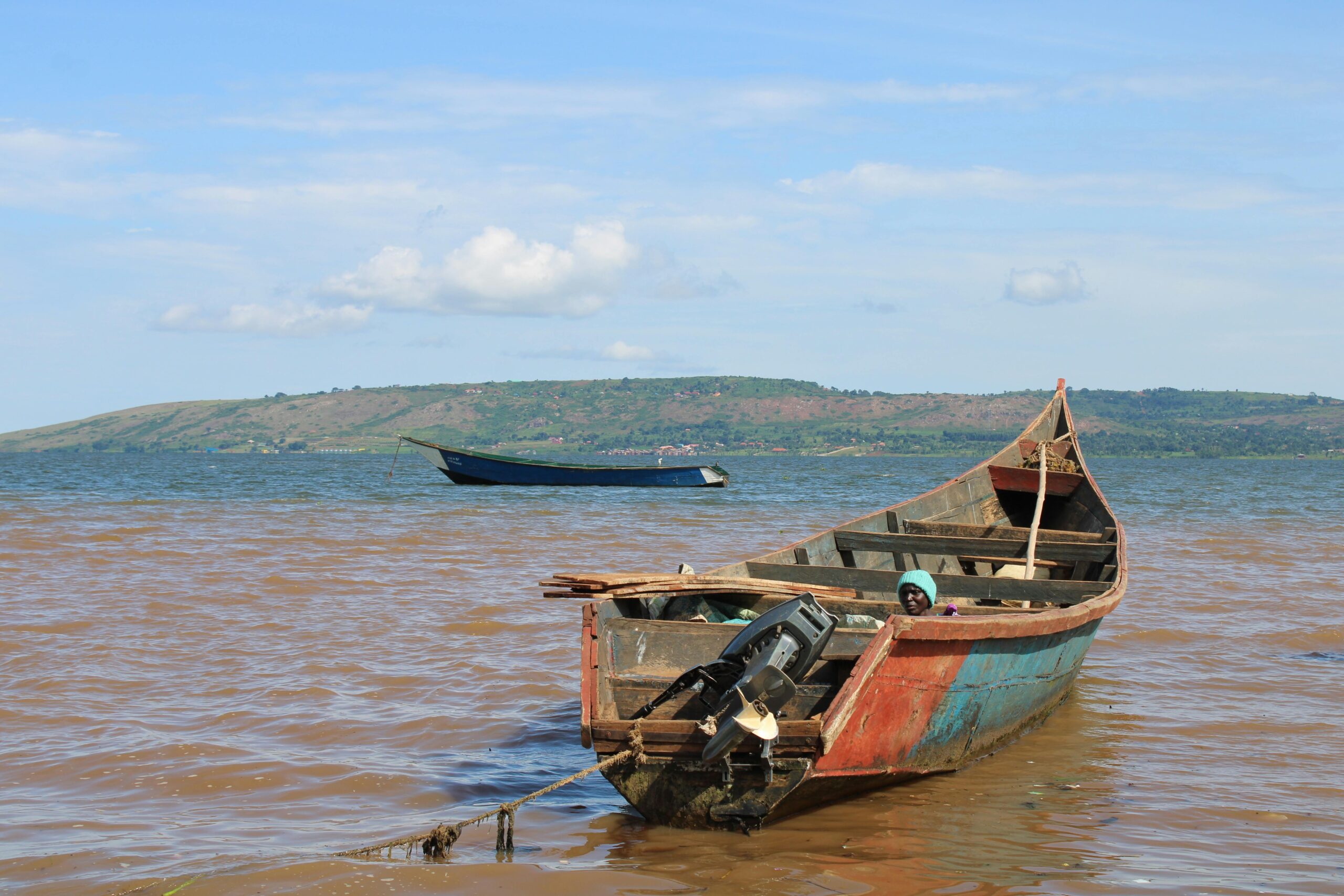 Uganda's Great Birding Arc Rustic fishing boat moored on Lake Victoria in Jinja, Uganda, under a clear sky.